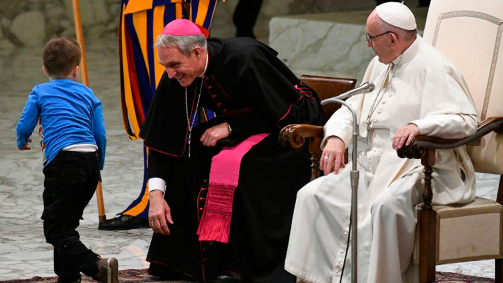 El Papa Francisco y el el Prefecto de la Casa Pontificia sonríen ante la interrupción de un niño con síndrome de Down. Foto: AFP