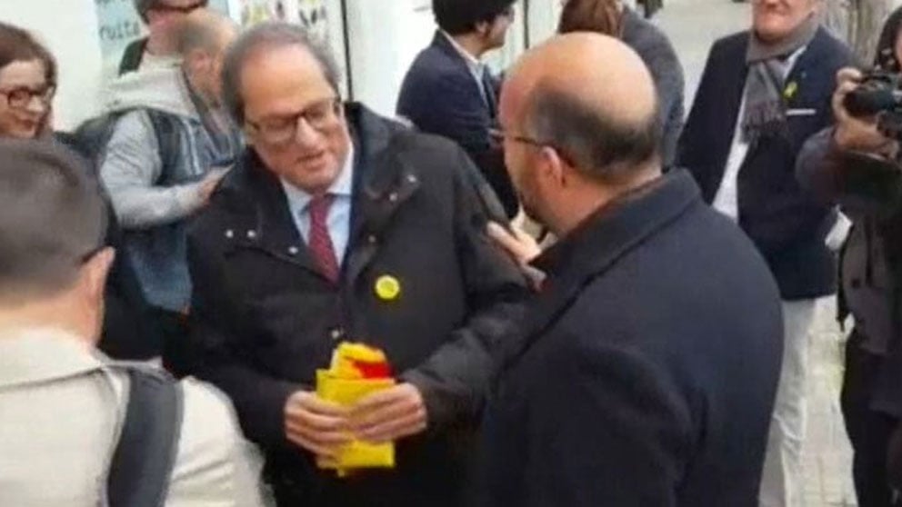 El líder del PP en el Ayuntamiento de El Prat de Llobregat (Barcelona), Miguel Ángel Ochoa e entrega a Quim Torra una bandera española y una catalana.