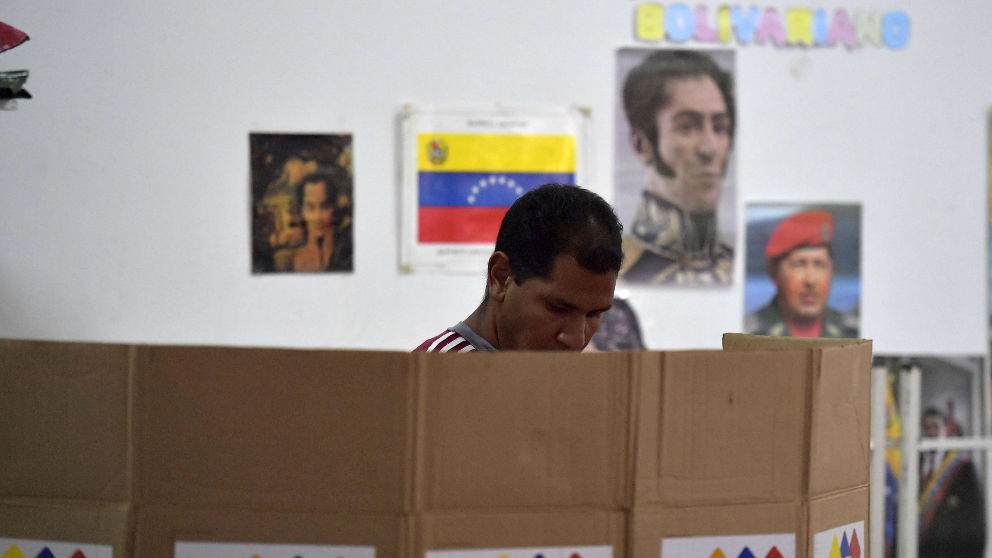 Un hombre deposita su voto en Venezuela