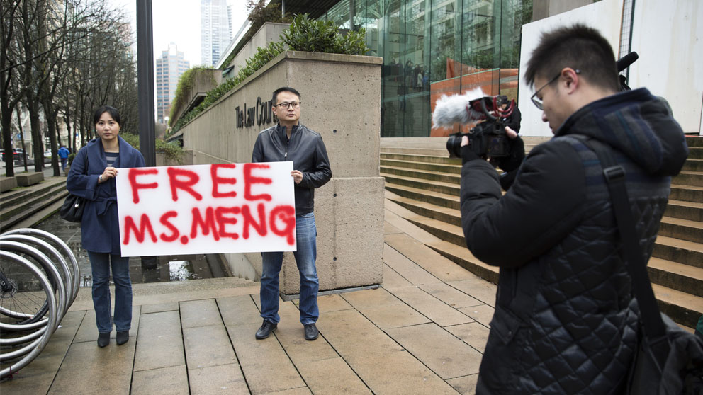 Dos personas muestran su apoyo a Meng Wanzhou, de Huawei (Foto: AFP)