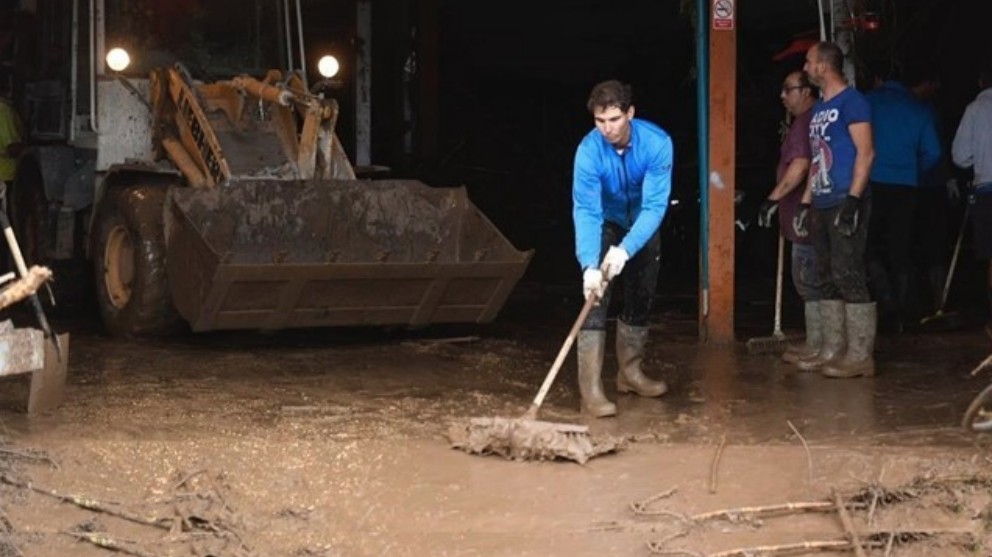 Nadal ayuda a achicar agua tras las inundaciones. (Europa Press)