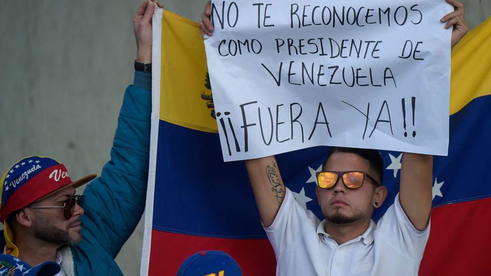 Dos venezolanos protestan contra la toma de posesión del dictador Nicolás Maduro como Presidente de Venezuela. Foto: AFP