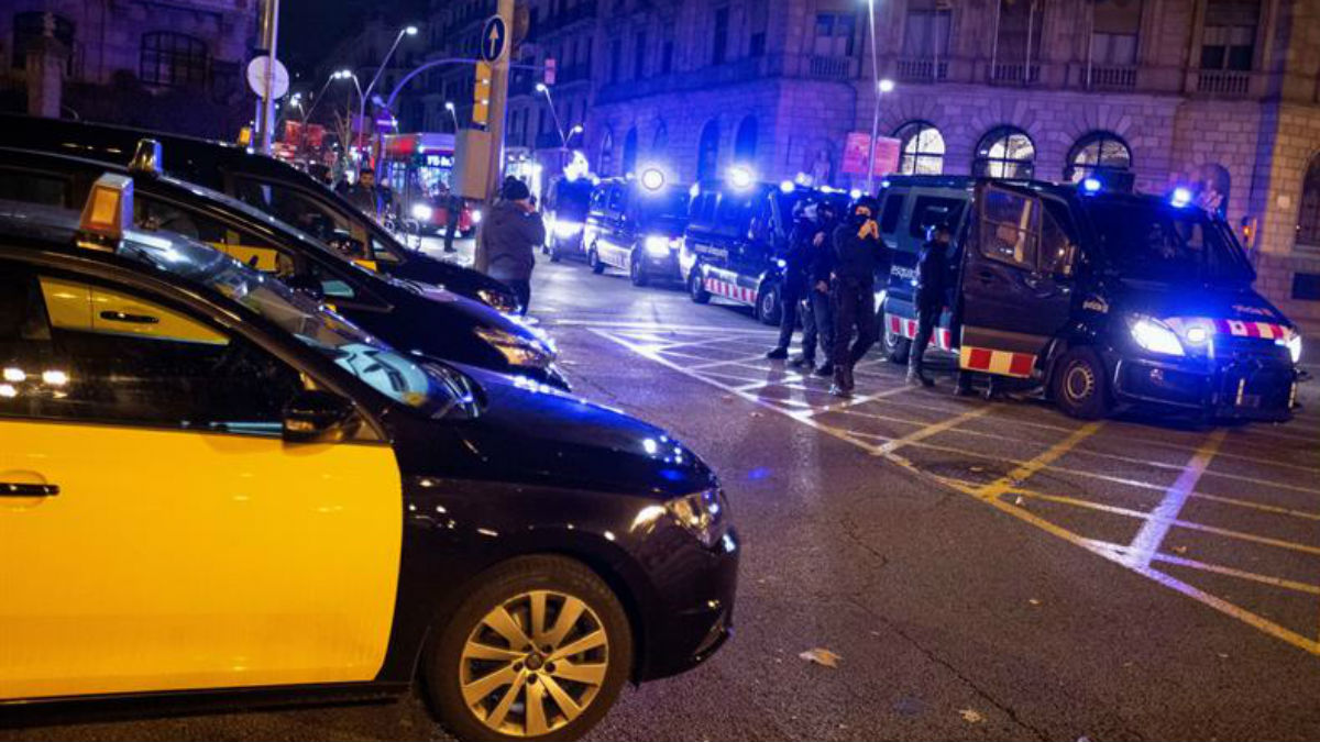 Dispositivo policial de los Mossos por el paro indefinido de los taxistas, esta noche en Barcelona. (EFE)