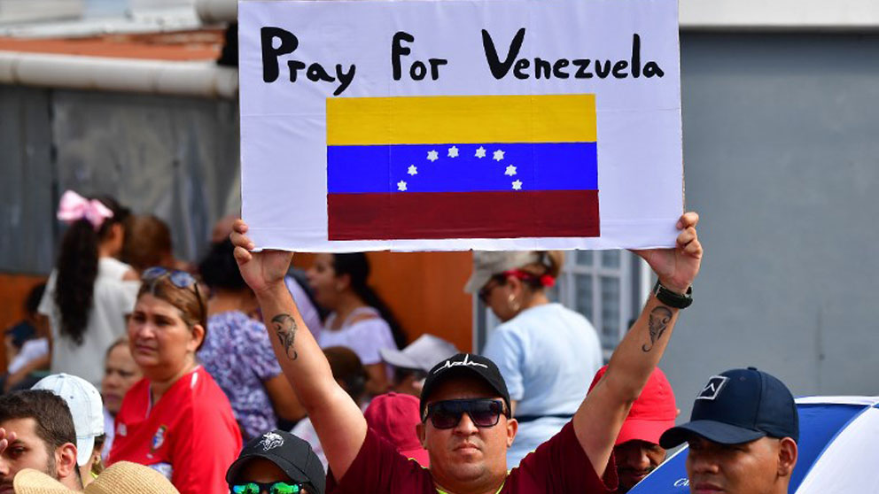 Un hombre sostiene una pancarta  pidiendo al Papa Francisco que rece por Venezuela en Panamá. Foto: AFP