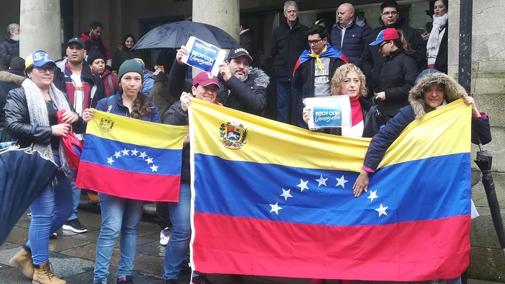 Un grupo de venezolanos enseña su enseñanacional en una plaza de Galicia. Foto: Europa Press