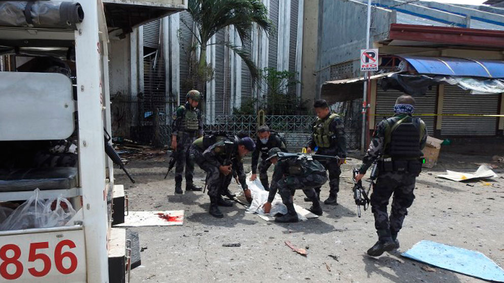 Las fuerzas de seguridad recogen uno de los cadáveres de los fallecidos en el atentado contra una iglesia católica en Filipinas. Foto: AFP