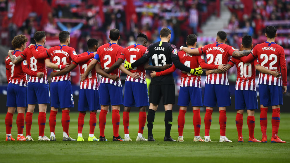 Los jugadores del Atlético, en el minuto de silencio previo al derbi. (AFP)