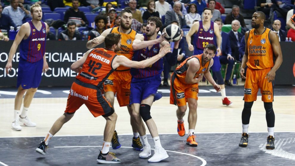 Tomic pelea por un balón con los interiores del Valencia. (ACB)