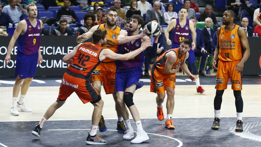 Tomic pelea por un balón con los interiores del Valencia. (ACB)
