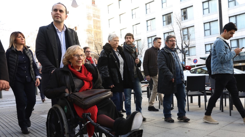Manuela Carmena en silla de ruedas empujada por José Manuel Calvo. (Foto. Madrid)