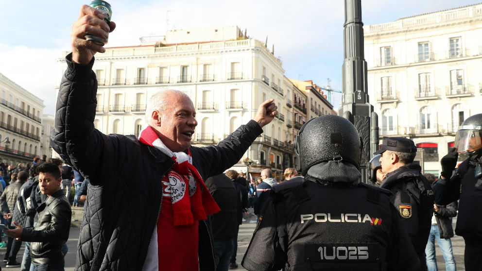 Un aficionado del Ajax junto a la Policía en la Puerta del Sol. (EFE)