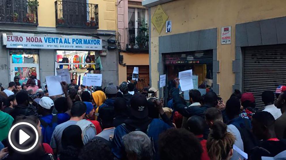 Un grupo de personas se concentra en torno a la pancarta que Carmena ha colocado en Lavapiés en memoria del ‘mantero’ muerto. Foto: Europa Press