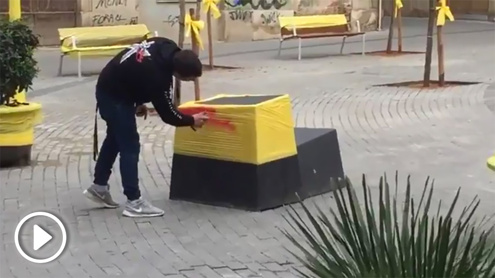 Una pareja transforma los plásticos amarillos en banderas de España en Olesa (Barcelona) mientras son increpados por separatistas