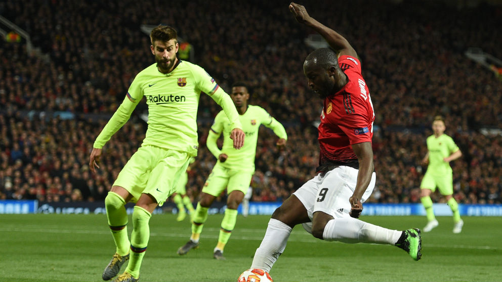 Gerard Piqué intenta robarle un balón a Romelu Lukaku durante el Manchester United – Barcelona. (AFP)