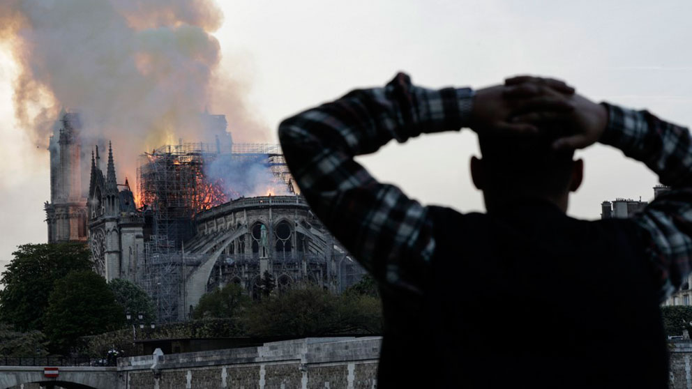 Un hombre se lleva las manos a la cabeza viendo el incendio de la catedral Notre Dame de París. Foto: AFP