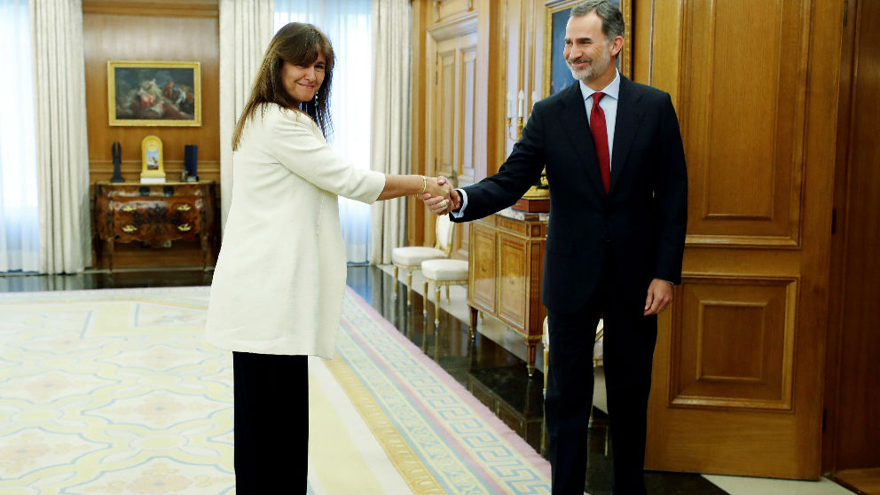 Laura Borrás, de JxCAT, muestra su pulsera amarilla mientras estrecha la mano del Rey, esta mañana, en le Palacio de la Zarzuela. (EFE)