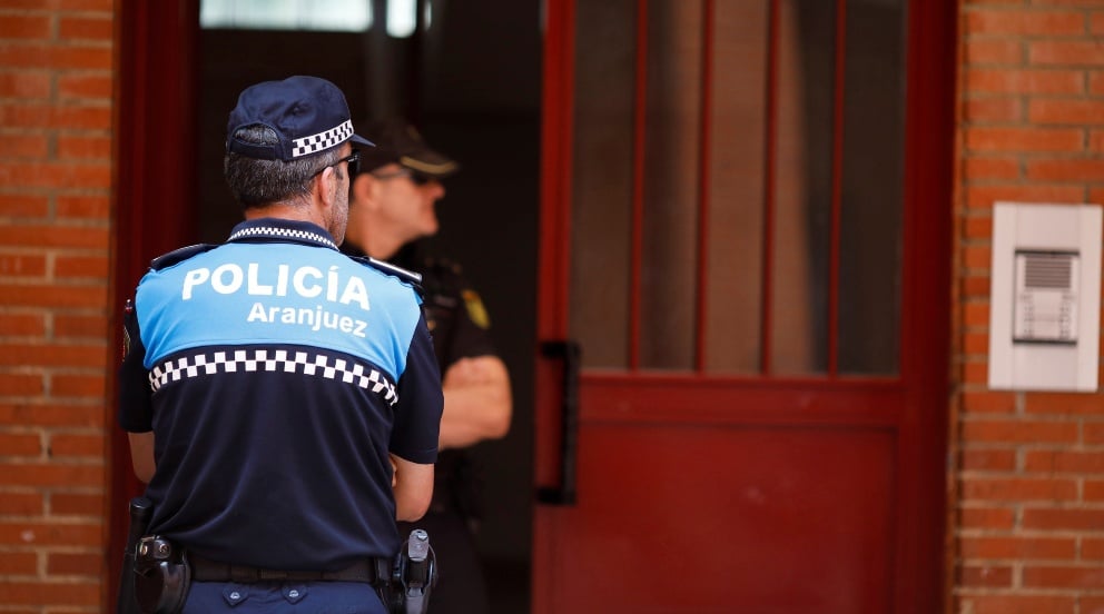 Un policía custodio el portal donde ocurrieron los asesinatos.