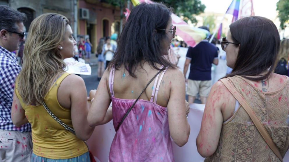 Marta Bosquet (c), presidenta de Parlamento de Andalucía, rociada con pintura por los radicales en la manifestación del Orgullo en Sevilla. (Foto: @martaboquet)