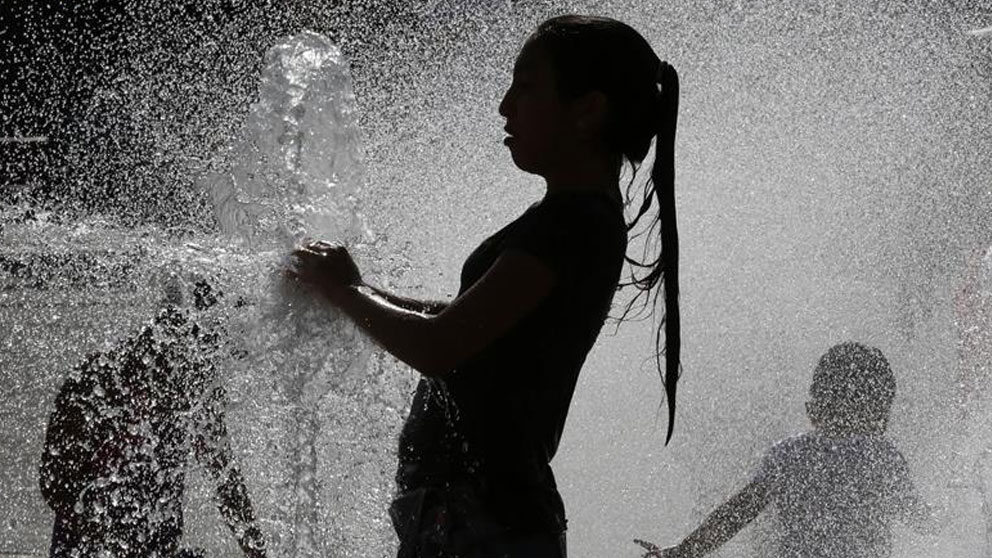 Varios jóvenes combaten las altas temperaturas registradas este sábado en Pamplona refrescándose en una de las fuentes de la capital navarra. Aemet ha informado de que hoy se han dado las temperaturas más altas de este episodio de ola de calor en Navarra. Foto: EFE