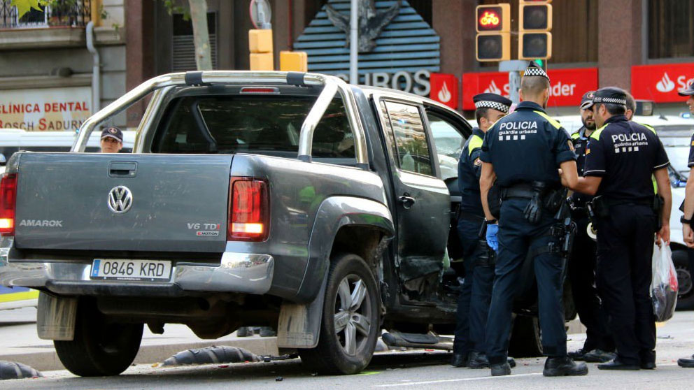 Agentes de la Guardia Urbana de Barcelona junto al coche del conductor drogado que ha provocado varios accidentes.