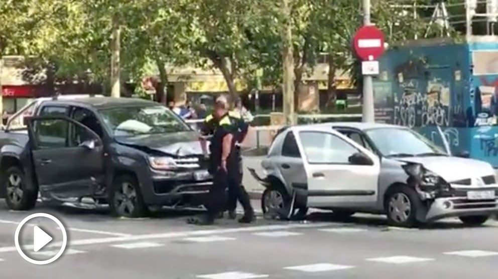 Agentes de la Guardia Urbana de Barcelona junto al coche del conductor drogado que ha provocado varios accidentes.