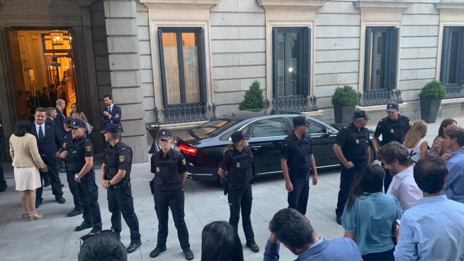 Agentes protegen el coche de Pedro Sánchez para que periodistas y diputados no se acerquen al presidente.