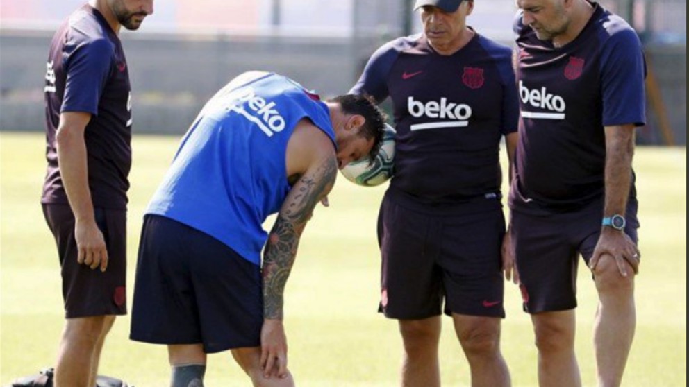 Leo Messi se duele ante la mirada de los preparadores del Barça.