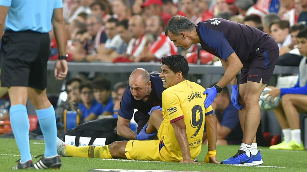 Luis Suárez es atendido sobre del césped de San Mamés. (AFP)