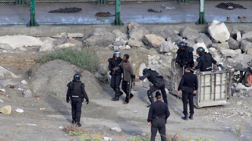 Agentes del GRS de la Guardia Civil detienen a algunos de los inmigrantes que asaltaron la valla de Ceuta en 2019.