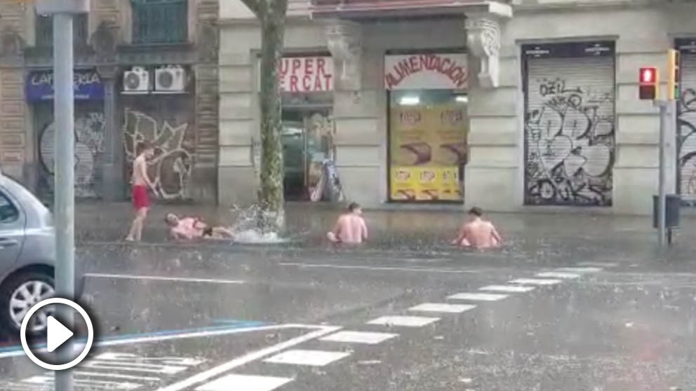 Grupo de jóvenes bañándose en la carretera bajo la lluvia