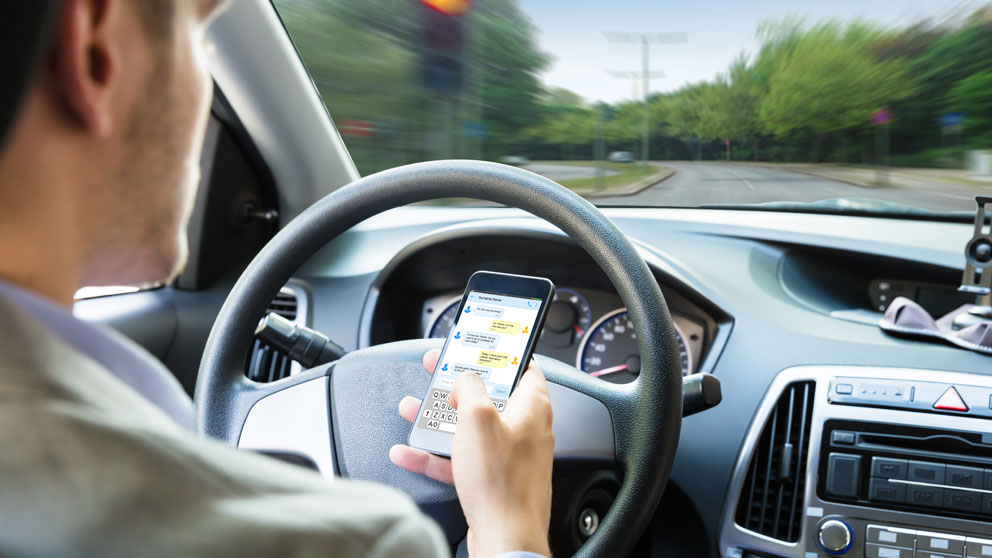 Un joven conduciendo mientras usa el móvil. Foto: iStock
