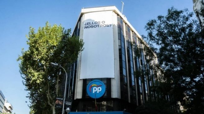 El PP despliega una lona en su sede central en Madrid con una pregunta: «¿Ellos o nosotros?»