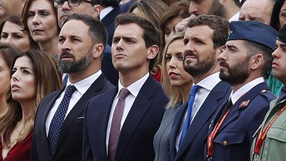 El líder de Vox Santiago Abascal (i), el líder de Ciudadanos Albert Rivera (c), y el presidente del PP Pablo Casado (d), en el madrileño Paseo de la Castellana, lugar en el que se celebra el desfile de la Fiesta Nacional, esta mañana en Madrid. Foto: EFE