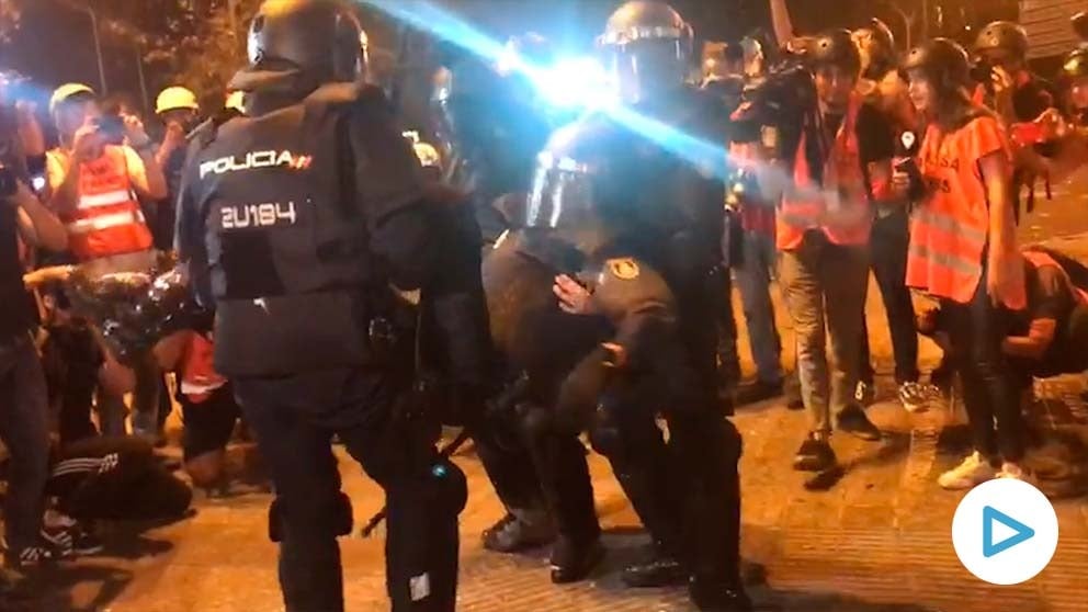 El policía herido en la plaza Urquinaona mientras es llevado inconsciente por compañeros.