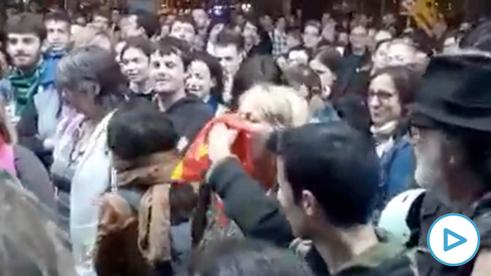 Un grupo de manifestantes simula sonarse los mocos con una bandera española
