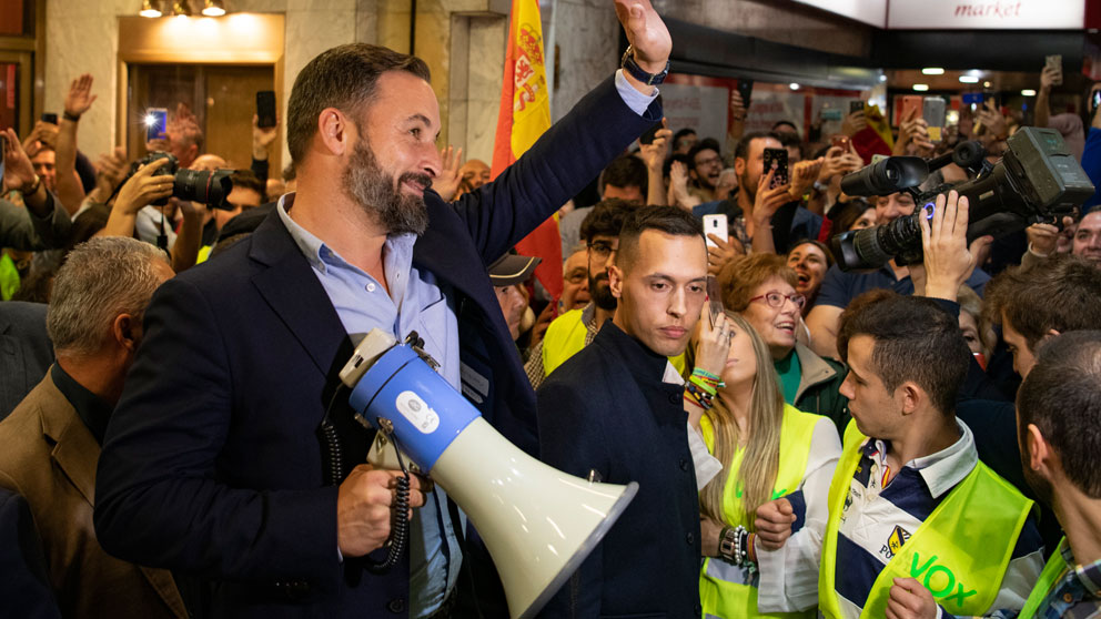 El presidente de Vox, Santiago Abascal saluda con un megáfono a la gente que no ha podido entrar a su acto público en el Teatro Quijano de Ciudad Real. Foto: EP
