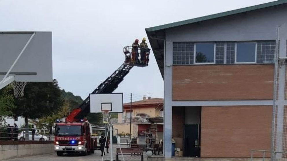Los bomberos retiran lazos amarillos de la fachada de un colegio electoral en Sarrià de Sarrià (Gerona). (Ep)