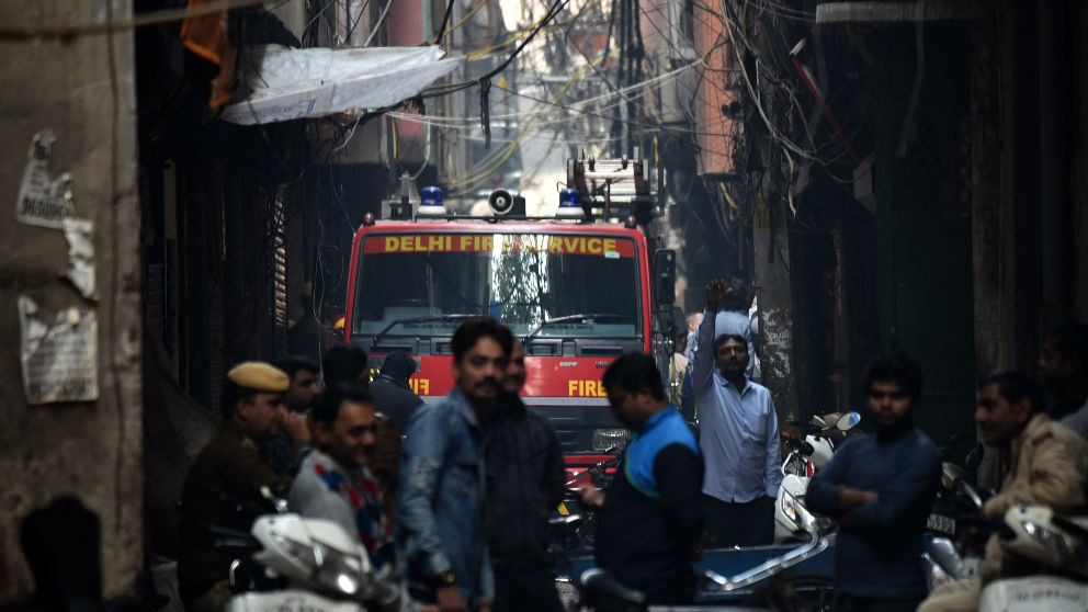 Los bomberos de Nueva Delhi intentan acceder al lugar del incendio que se ha cobrado al menos 43 muertos. (Afp)