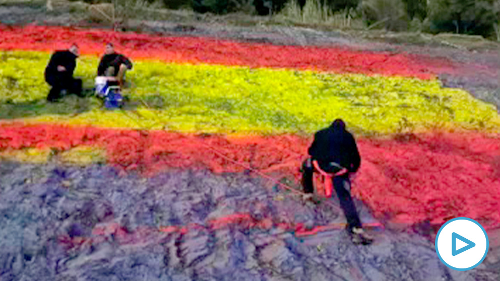 Momento en el que los activistas vuelven a pintar la bandera de España en la AP-7