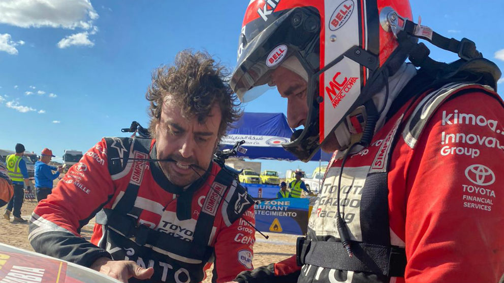 Fernando Alonso y Marc Coma intentando reparar el coche. (Foto: Rally Dakar)