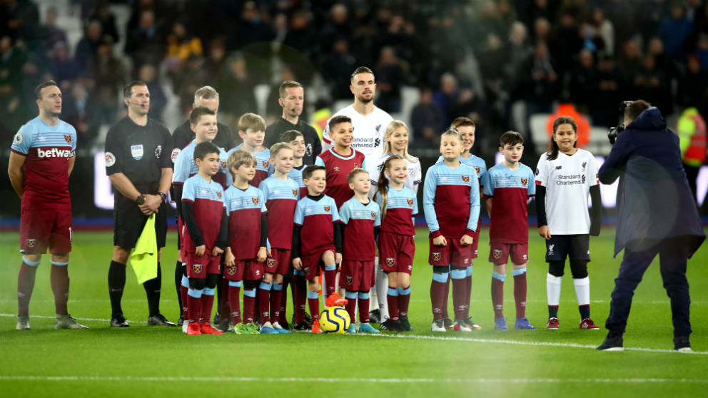 Un grupo de niños del West Ham posan con los capitanes y los árbitros antes de su partido ante el Liverpool (Getty).