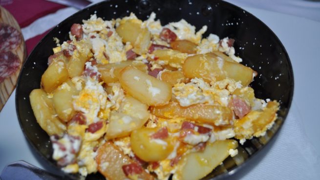 Patatas caldosas a lo pobre con jamón ibérico y huevos rotos