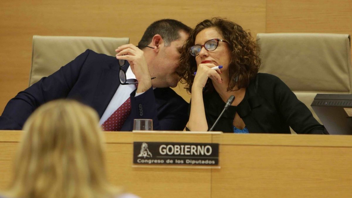 El vicepresidente primero de la Comisión de Hacienda del Congreso de los Diputados, José Luis Ramos Rodríguez (PSOE), habla con la ministra de Hacienda y portavoz del Gobierno, María Jesús Montero, momentos antes de su comparecencia en la Comisión para explicar las líneas generales de la política de su Departamento.