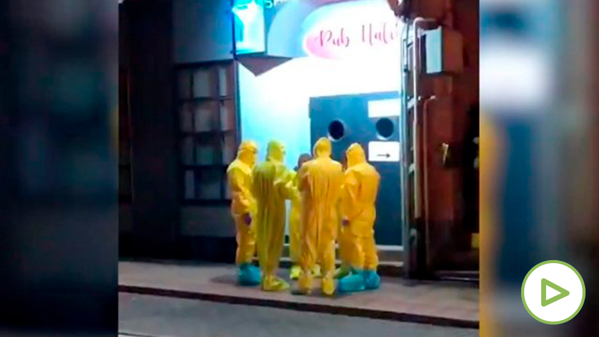 Técnicos sanitarios con trajes de aislamiento a la puerta del pub donde se encontraba la mujer a la que se ha analizado por sospechas de coronavirus.