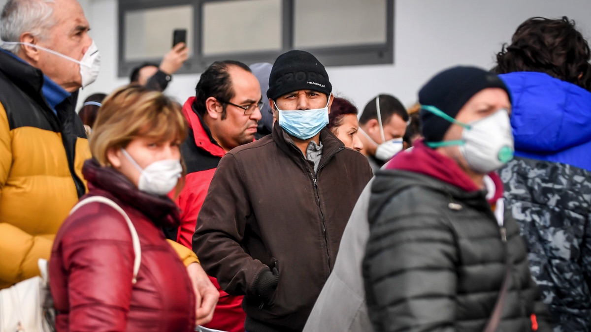 Italianos con máscaras en frente de un supermercado esperando para comprar reservas en plena crisis del coronavirus. (Foto. EP)