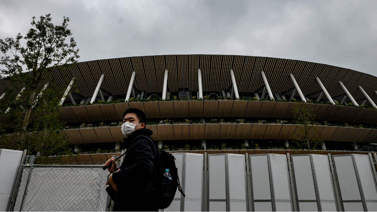 Un hombre pasea con máscara ante el Estadio Nacional de Tokio. (AFP)