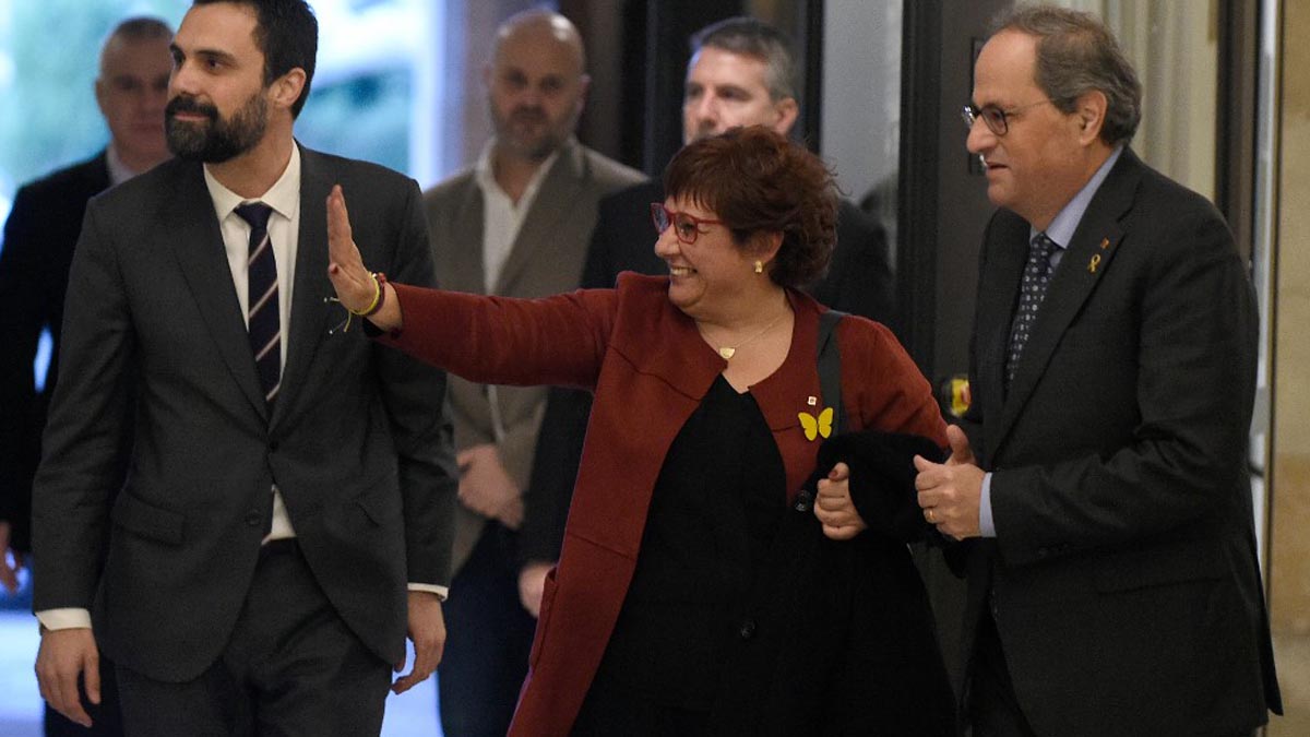 Dolors Bassa, la exconsejera catalana de Trabajo encarcelada por su implicación en la celebración del referéndum ilegal del 1-O., saluda entre Roger Torrent y Quim Torra. Foto: AFP
