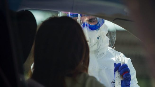 Un hombre recoge su prueba desde el coche.