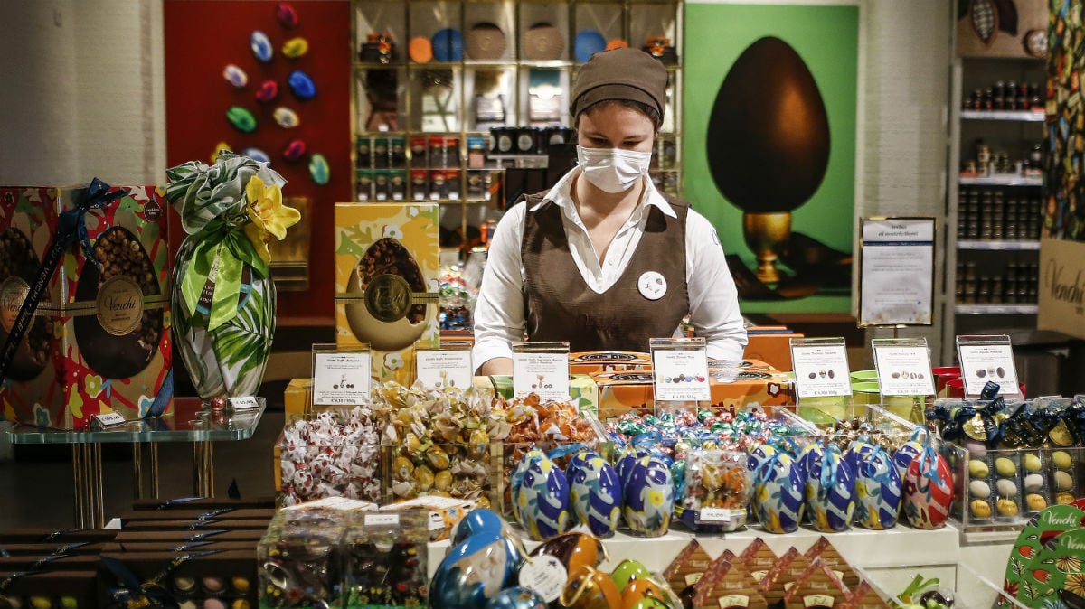 Una dependienta con mascarilla atiende en una pastelería de Roma (Foto: Europa Press).