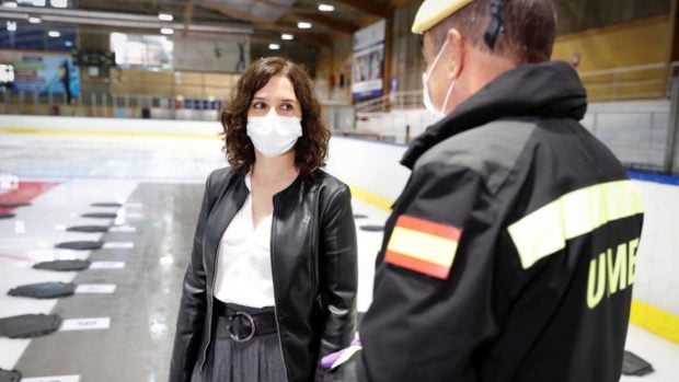 La presidenta de la Comunidad de Madrid, Isabel Díaz Ayuso, habla con un efectivo de la Unidad Militar de Emergencias (UME) en el Palacio de Hielo de Majadahonda, convertido en morgue de manera temporal a causa del coronavirus. 